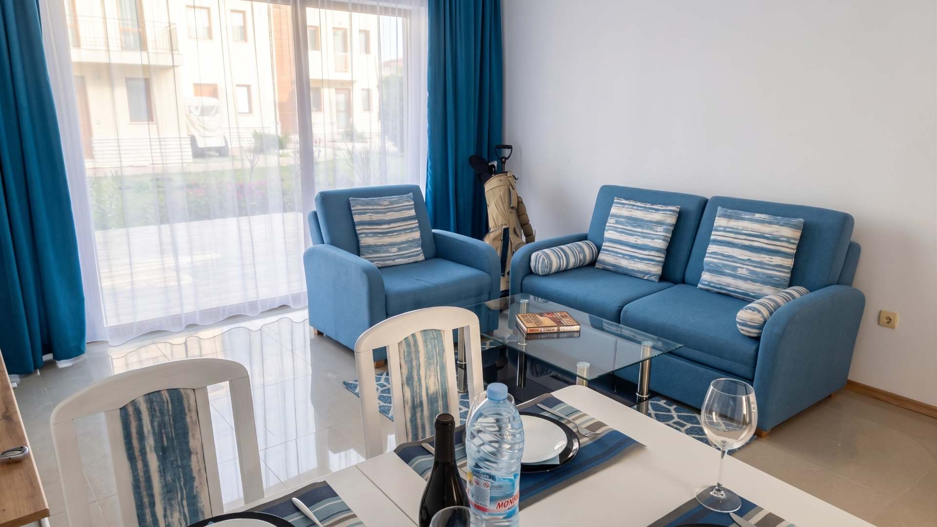Living room with dining table, sofa and golf equipment.